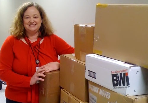 Food for Fines Image of employee standing by boxes of donated food